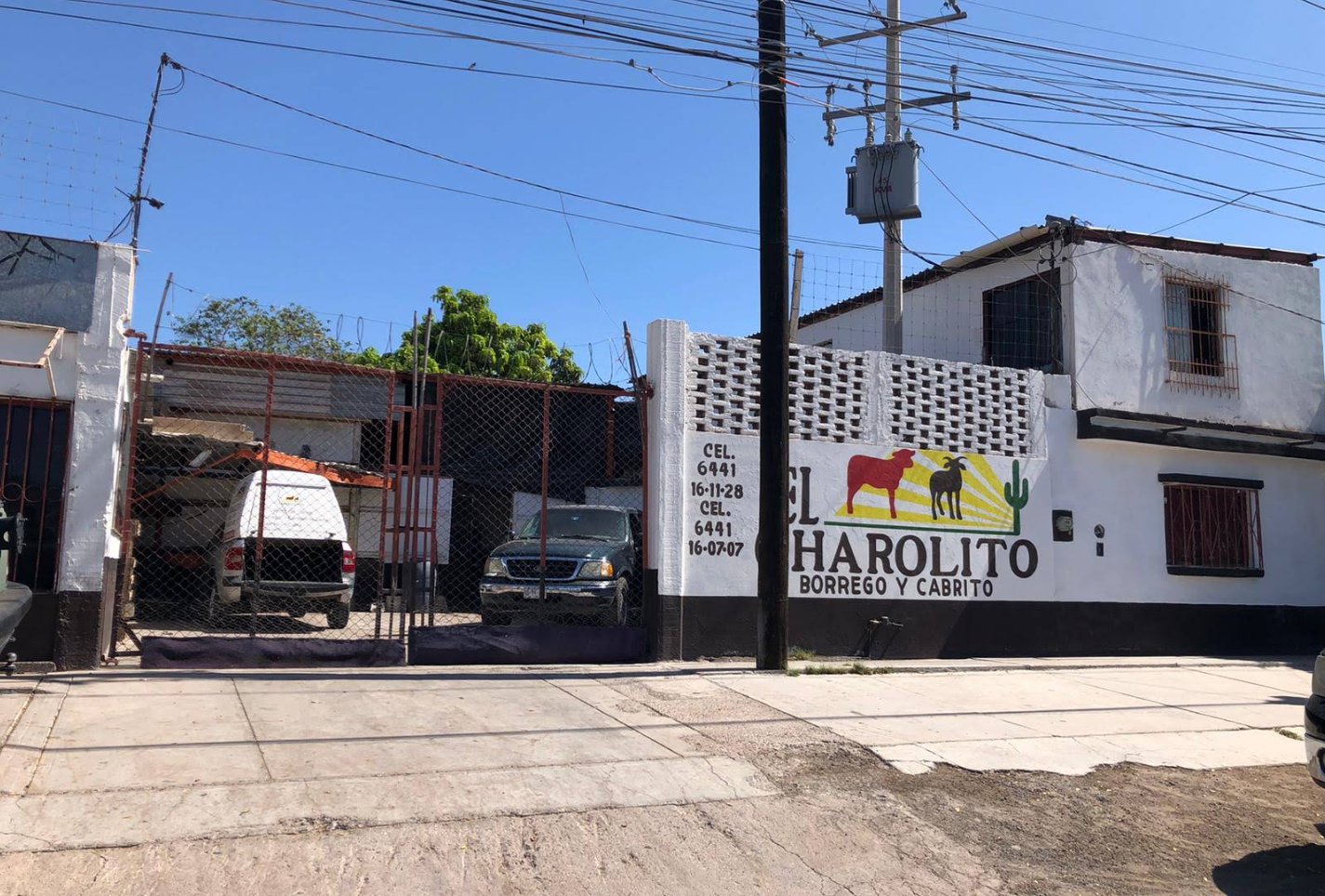 La fachada de El Charolito: la barda blanca con el letrero pintado de un borrego y un cabrito, y el portón de entrada.