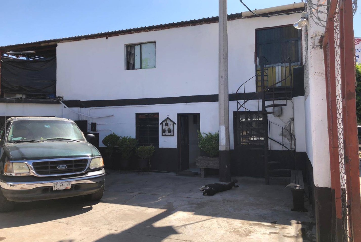 El patio del local, con la camioneta estacionada y la escalera al segundo piso.